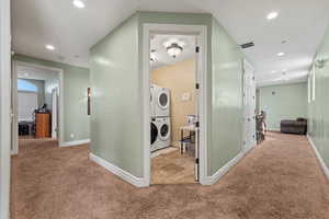 Corridor with recessed lighting, stacked washing maching and dryer, carpet, and visible vents