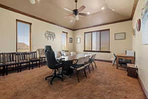 Carpeted dining space with ceiling fan, baseboards, lofted ceiling, and plenty of natural light