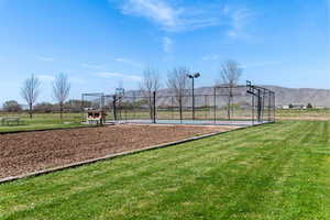 View of sport court featuring a yard, a mountain view, fence, and community basketball court