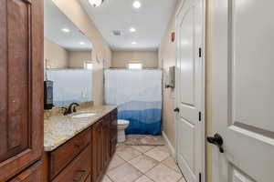 Bathroom featuring vanity, tile patterned flooring, visible vents, and recessed lighting