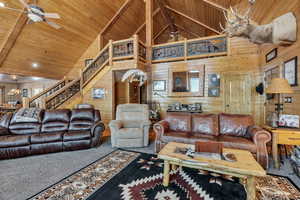 Living area featuring ceiling fan, high vaulted ceiling, carpet flooring, and wood ceiling