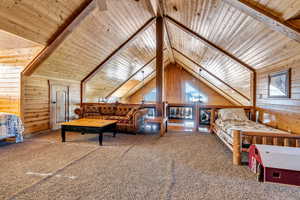 Carpeted bedroom with wood ceiling, wood walls, and vaulted ceiling