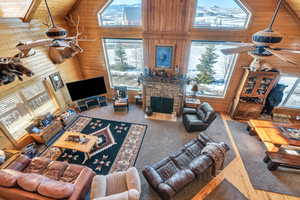 Living area featuring high vaulted ceiling and wooden walls