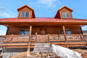 Log home with metal roof and covered porch