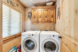 Laundry area with separate washer and dryer and cabinet space