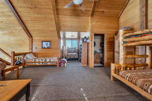 Carpeted bedroom featuring wooden ceiling, wood walls, and beamed ceiling