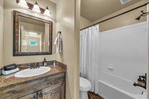 Full bath with toilet, vanity, shower / bath combination with curtain, and tile patterned flooring