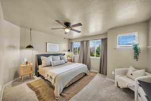 Bedroom featuring baseboards, ceiling fan, light carpet, and a textured ceiling