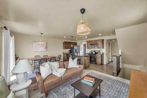 Living area featuring baseboards, recessed lighting, and a chandelier