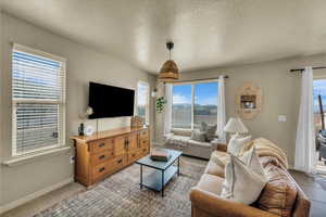 Living area with baseboards and a textured ceiling