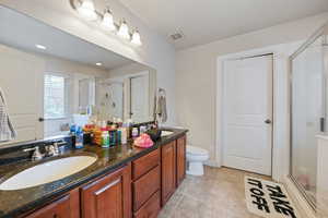 Full bath with a shower stall, a sink, tile patterned flooring, and visible vents