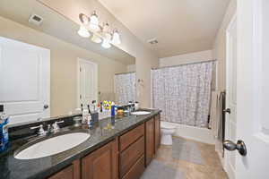 Bathroom featuring double vanity, a sink, and visible vents