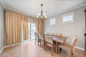 Dining room with visible vents, baseboards, an inviting chandelier, and ornamental molding