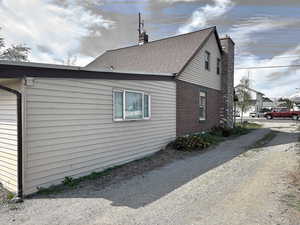 View of side of home featuring a chimney and brick siding