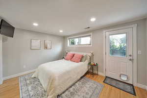 Bedroom featuring light wood-style floors, baseboards, visible vents, and recessed lighting