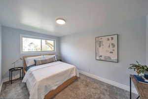 Bedroom featuring carpet and baseboards