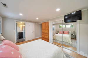 Bedroom featuring light wood-type flooring, visible vents, and recessed lighting
