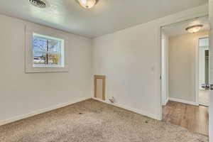 Carpeted empty room with baseboards and visible vents