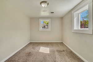Empty room featuring visible vents, carpet flooring, and baseboards