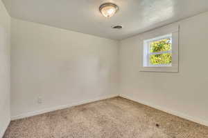Carpeted spare room with baseboards and visible vents