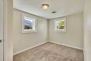 Unfurnished room with baseboards, carpet flooring, and visible vents