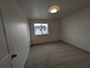 Unfurnished room featuring visible vents, baseboards, light colored carpet, and a textured ceiling