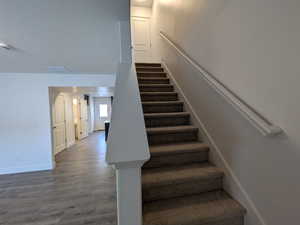 Stairway with baseboards and wood finished floors