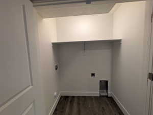 Clothes washing area featuring laundry area, dark wood finished floors, hookup for a washing machine, electric dryer hookup, and baseboards