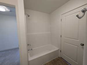 Bathroom with baseboards and shower / washtub combination