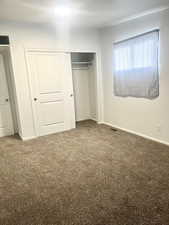 Unfurnished bedroom featuring a closet, baseboards, carpet, and visible vents
