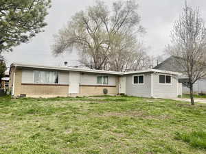 Exterior space with a yard, brick siding, and cooling unit