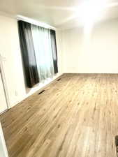 Spare room featuring visible vents, baseboards, and wood finished floors
