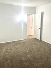 Carpeted empty room featuring baseboards