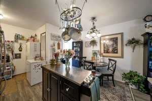 Kitchen featuring wood finished floors, cabinetry, decorative light fixtures