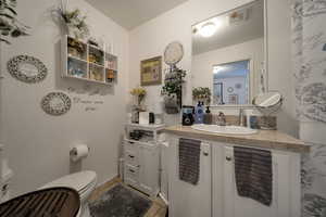 Bathroom with vents, patterned flooring, vanity, and toilet