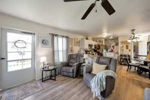 Living area featuring light wood-style floors and ceiling fan