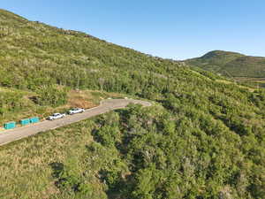 Aerial overview of property's location featuring a heavily wooded area and a mountainous background