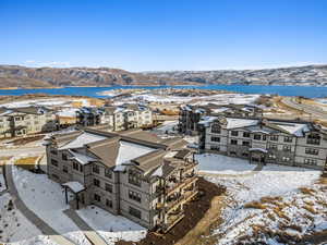 Snowy aerial view featuring a water and mountain view and a residential view