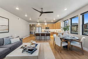 Living area with baseboards, light wood-type flooring, recessed lighting, a ceiling fan, and visible vents