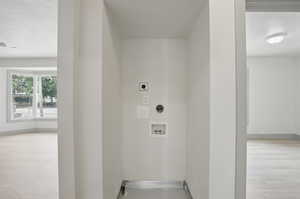Washroom featuring electric dryer hookup, washer hookup, and baseboards