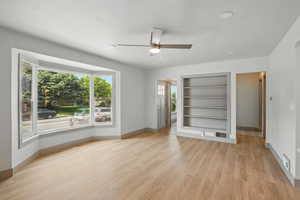 Spare room with ceiling fan, baseboards, built in features, and plenty of natural light