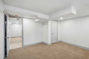 Finished below grade area with light carpet, recessed lighting, and baseboards