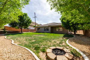 View of yard featuring a fire pit and a fenced backyard