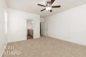 Unfurnished bedroom with ensuite bath, ceiling fan, carpet floors, and baseboards