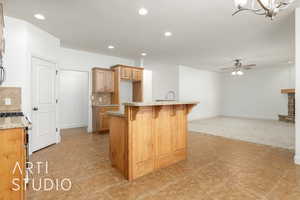 Kitchen featuring ceiling fan with notable chandelier, backsplash, a kitchen bar, and light stone counters