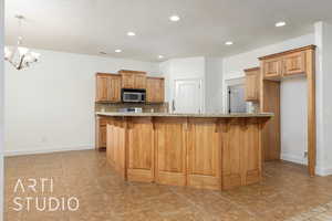 Kitchen with stainless steel microwave, recessed lighting, brown cabinets, tasteful backsplash, and a breakfast bar