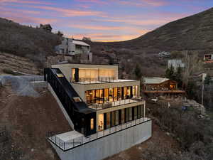 Back of house featuring a balcony and a mountain view