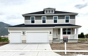View of front of home featuring stone siding, an attached garage, roof with shingles, a porch, and driveway