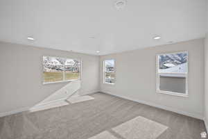 Carpeted spare room featuring visible vents, baseboards, and recessed lighting