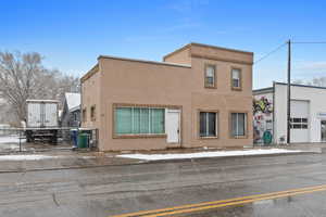 View of front facade with stucco siding and fence